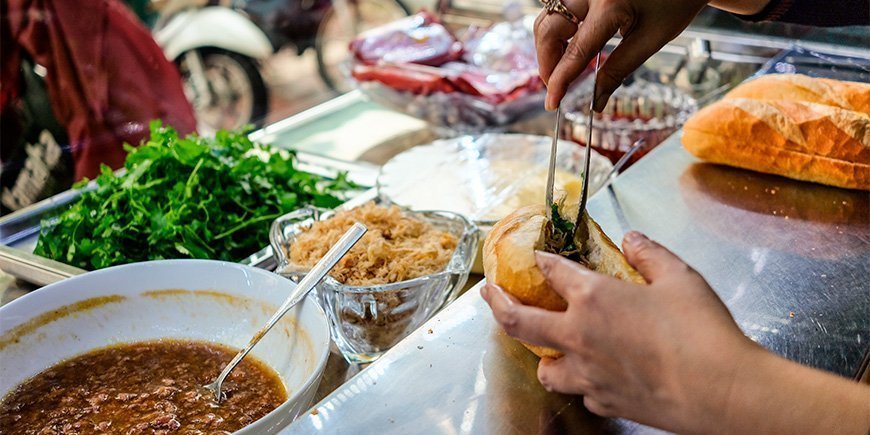 Nainen tekee Banh Mi -voileipää Ho Chi Minh Cityssä, Vietnamissa.
